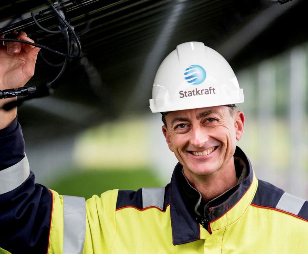 Man standing beside solar panels